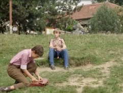 Petr sedí na trávě
